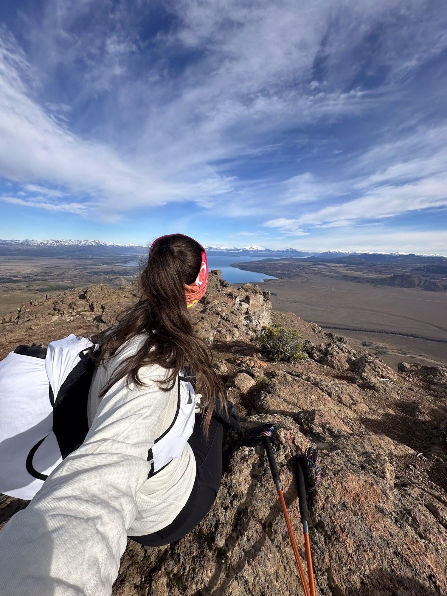 Trilheira no topo de morro rochoso contempla lago e planície em Bariloche