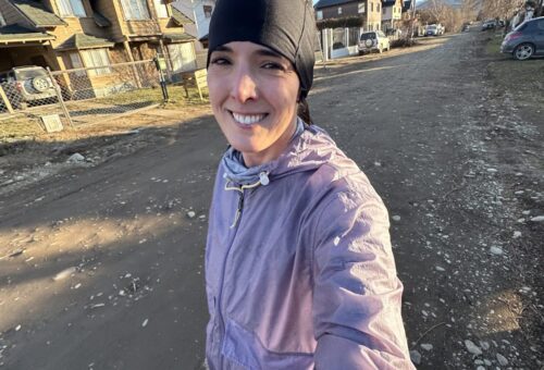 o que fazer em Bariloche no inverno: Mulher sorridente em selfie durante corrida nas ruas de Bariloche no inverno - Vale Liberdade