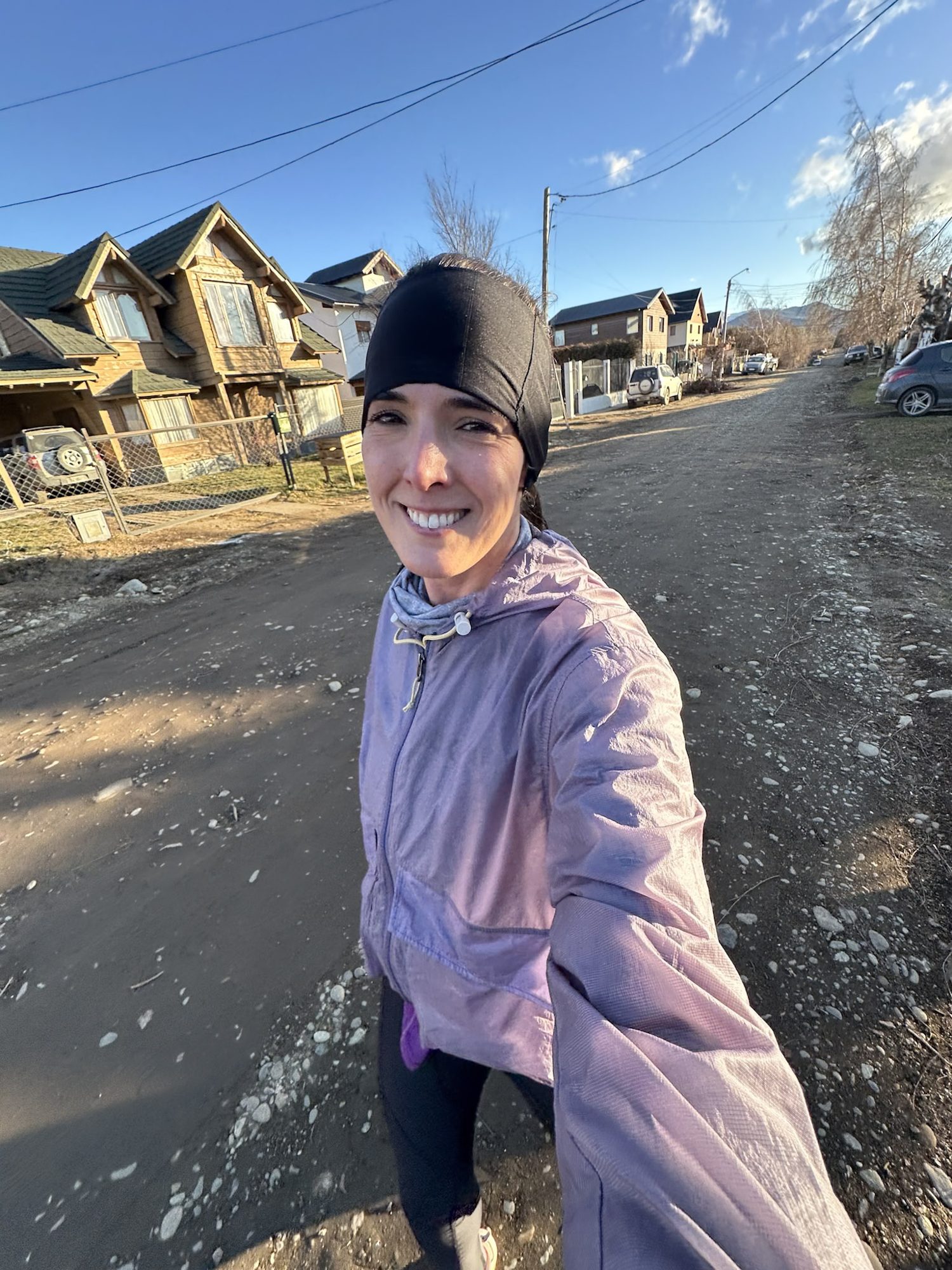 o que fazer em Bariloche no inverno: Mulher sorridente em selfie durante corrida nas ruas de Bariloche no inverno - Vale Liberdade