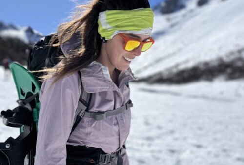 Bariloche em agosto: Jovem caminhante com óculos de sol amarelos e mochila em paisagem nevada de Bariloche - Vale Liberdade