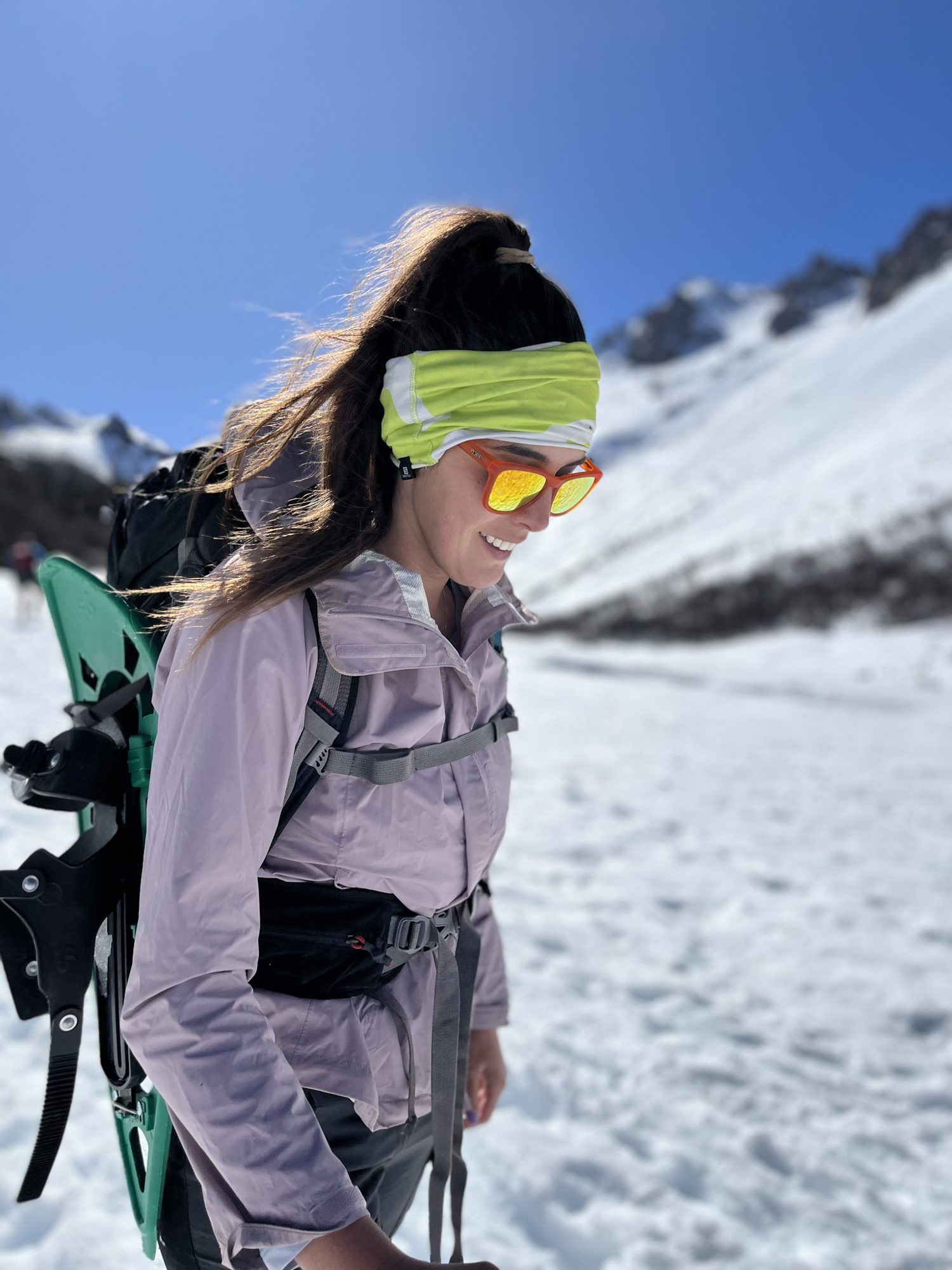 Bariloche em agosto: Jovem caminhante com óculos de sol amarelos e mochila em paisagem nevada de Bariloche - Vale Liberdade