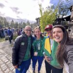 Requisitos para entrar na Argentina e voltar ao Brasil: grupo de quatro pessoas posando para selfie com roupas verdes e bandeira do Brasil em Villa la Angostura - Vale Liberdade