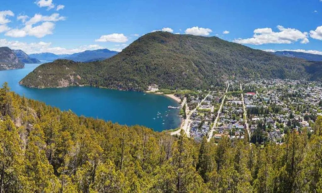 Duas vans camper estacionadas em campo aberto com floresta ao fundo em San Martin de Los Andes - Vale Liberdade