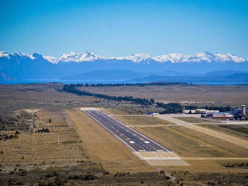 três amigos posam juntos para selfie na área de embarque do aeroporto de Bariloche - Vale Liberdade