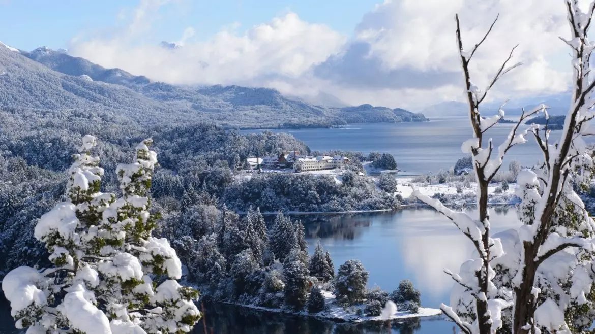 Bariloche em Julho: duas pessoas conversam com vista para montanhas nevadas em Bariloche - Vale Liberdade
