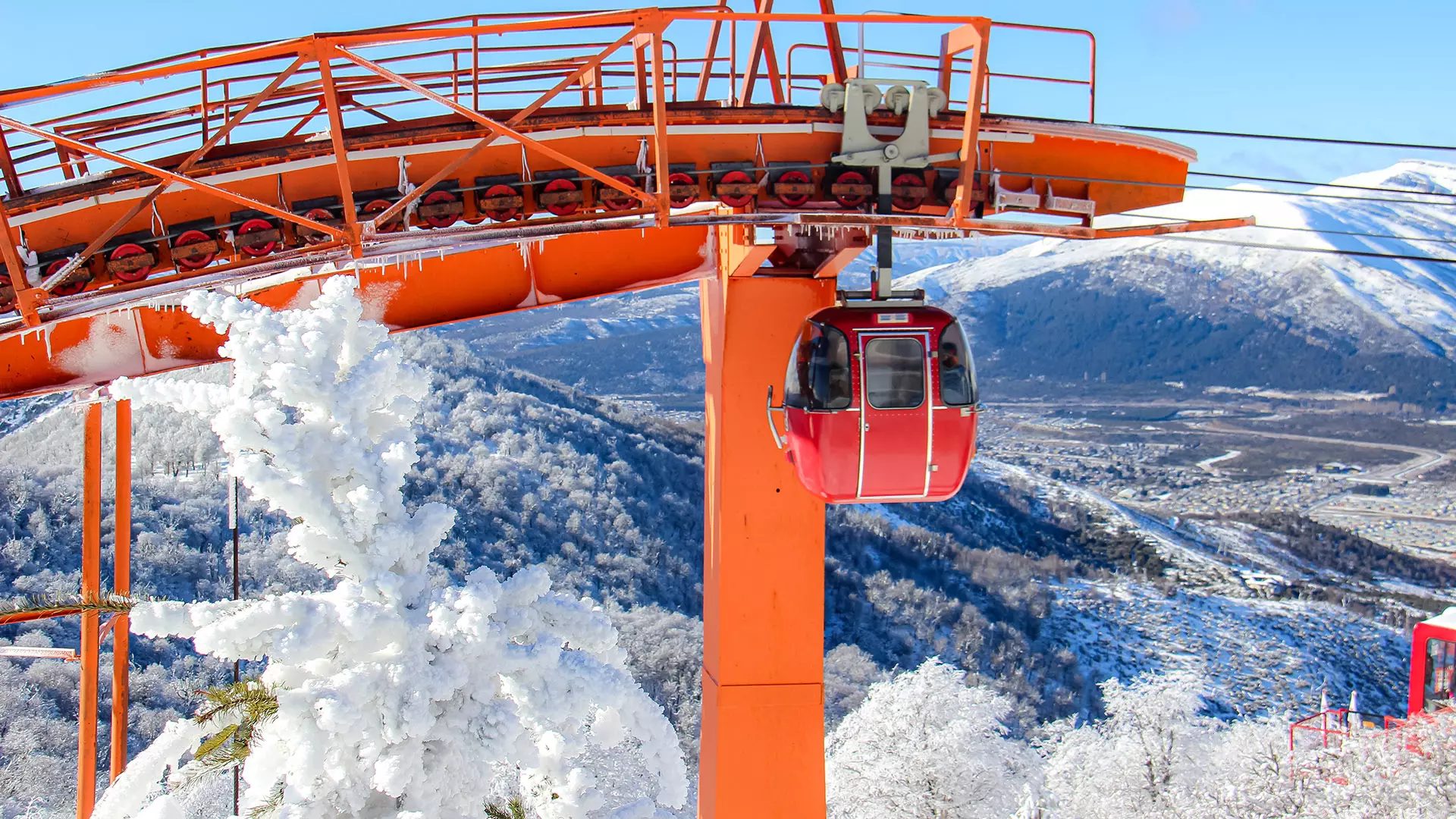 Bariloche em Julho: duas pessoas conversam com vista para montanhas nevadas em Bariloche - Vale Liberdade