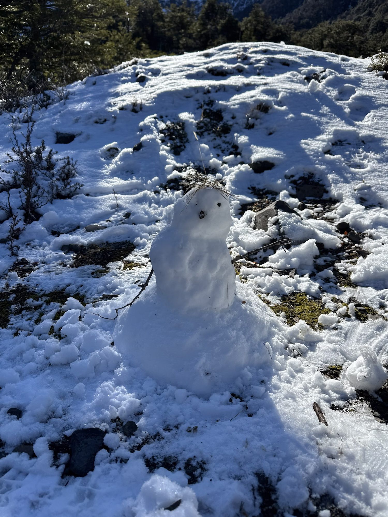 Bariloche em Setembro: Pequeno boneco de neve construído em encosta rochosa com neve em Bariloche - Vale Liberdade
