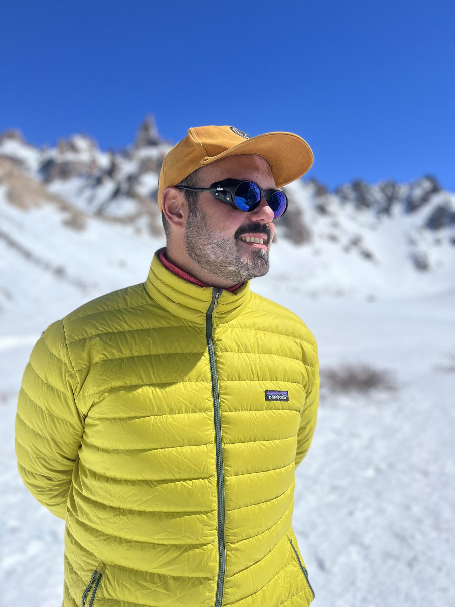 cerro catedral: Homem com jaqueta amarela Patagonia e boné laranja em paisagem nevada de Bariloche - Vale Liberdade