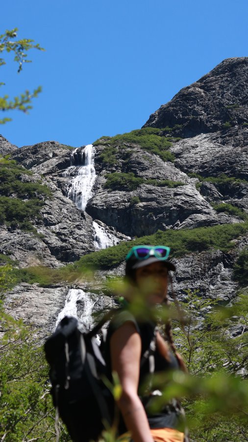Mochileiro observando cascata na trilha do Refúgio Frey