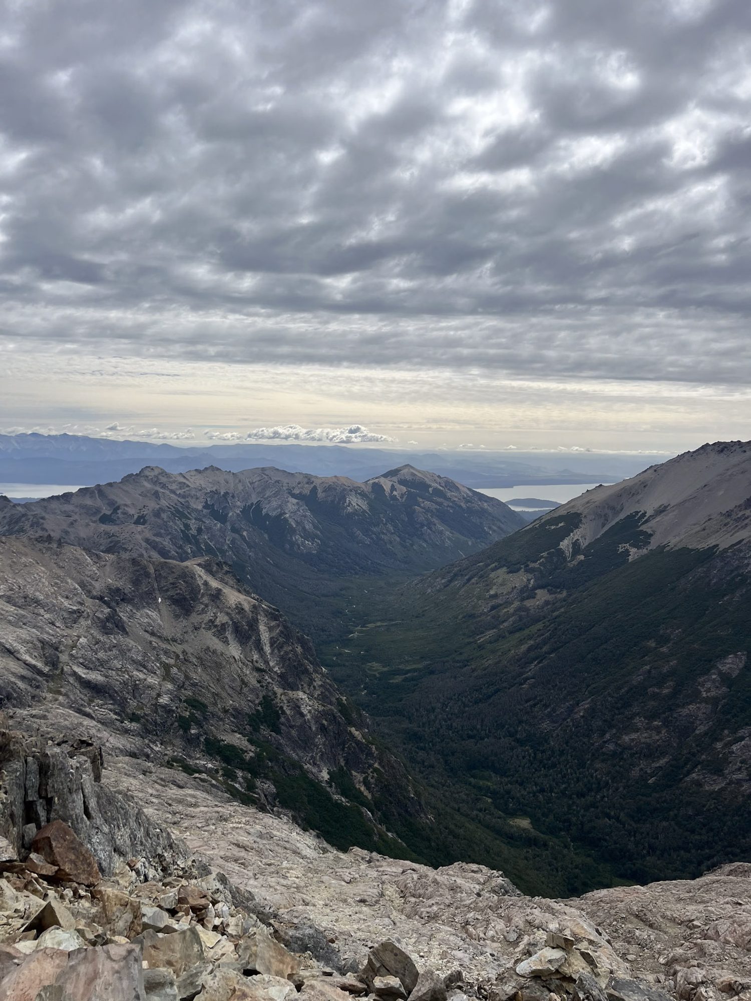 bariloche em fevereiro: vista panorâmica de vale glacial com floresta e lago ao fundo desde cume rochoso em Bariloche - Vale Liberdade