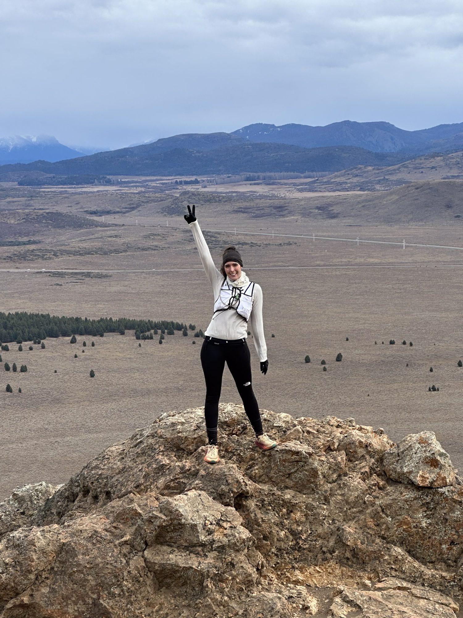 Isla Victoria: Mulher no topo de uma rocha comemorou com o braço erguido, com vista para o vale aberto de Bariloche - Vale Liberdade