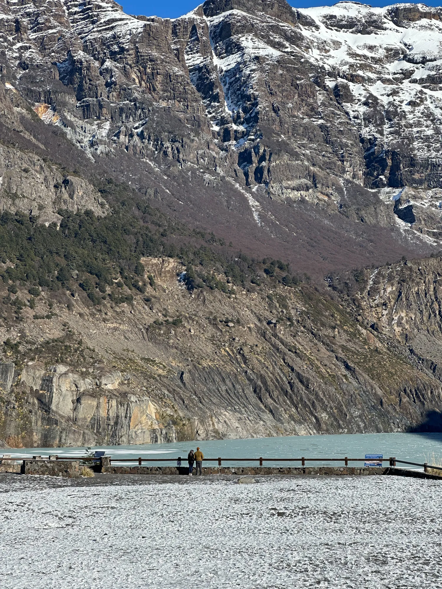 bariloche em abril: Casal observando o Lago Frías cercado por montanhas nevadas e rochas escarpadas na região de Bariloche, Patagônia argentina