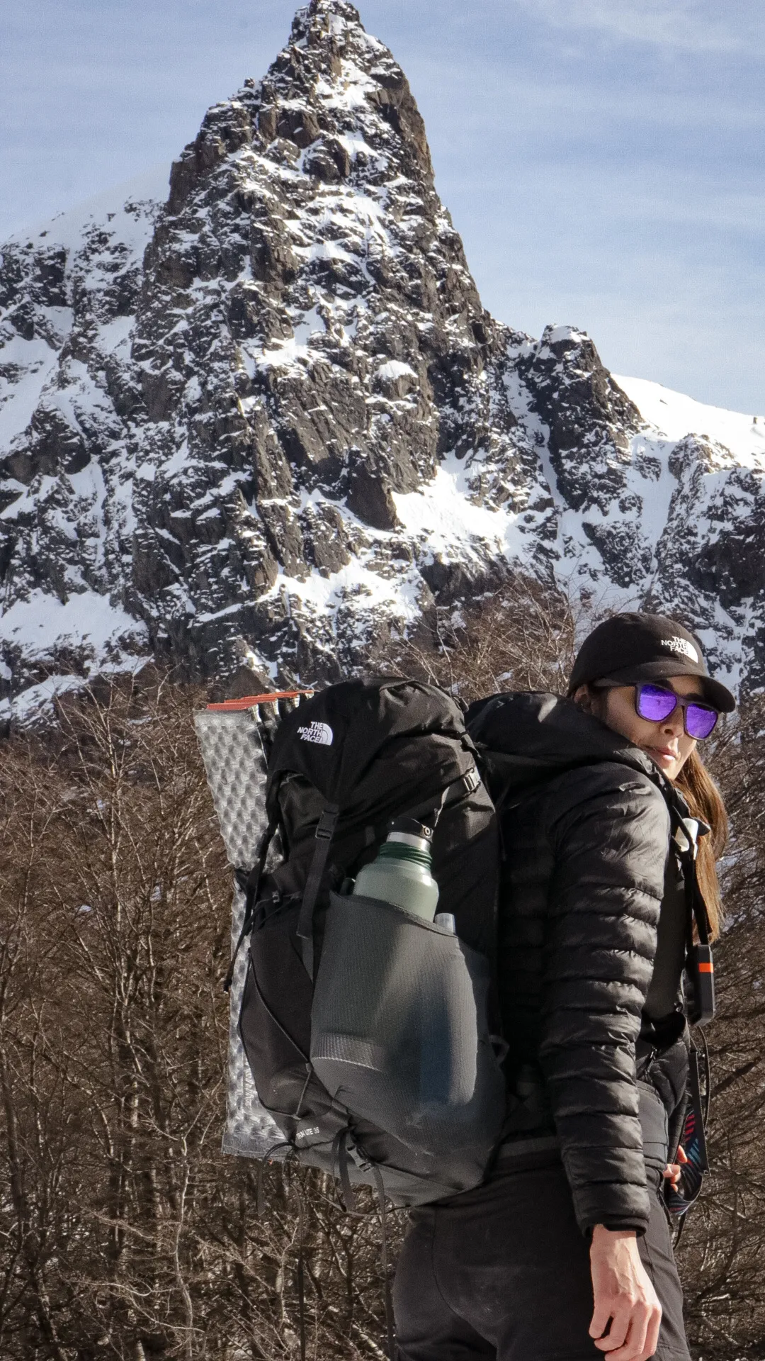 bariloche em maio: Trilheira com mochila de trekking The North Face diante de pico rochoso coberto de neve em Bariloche, Patagônia argentina