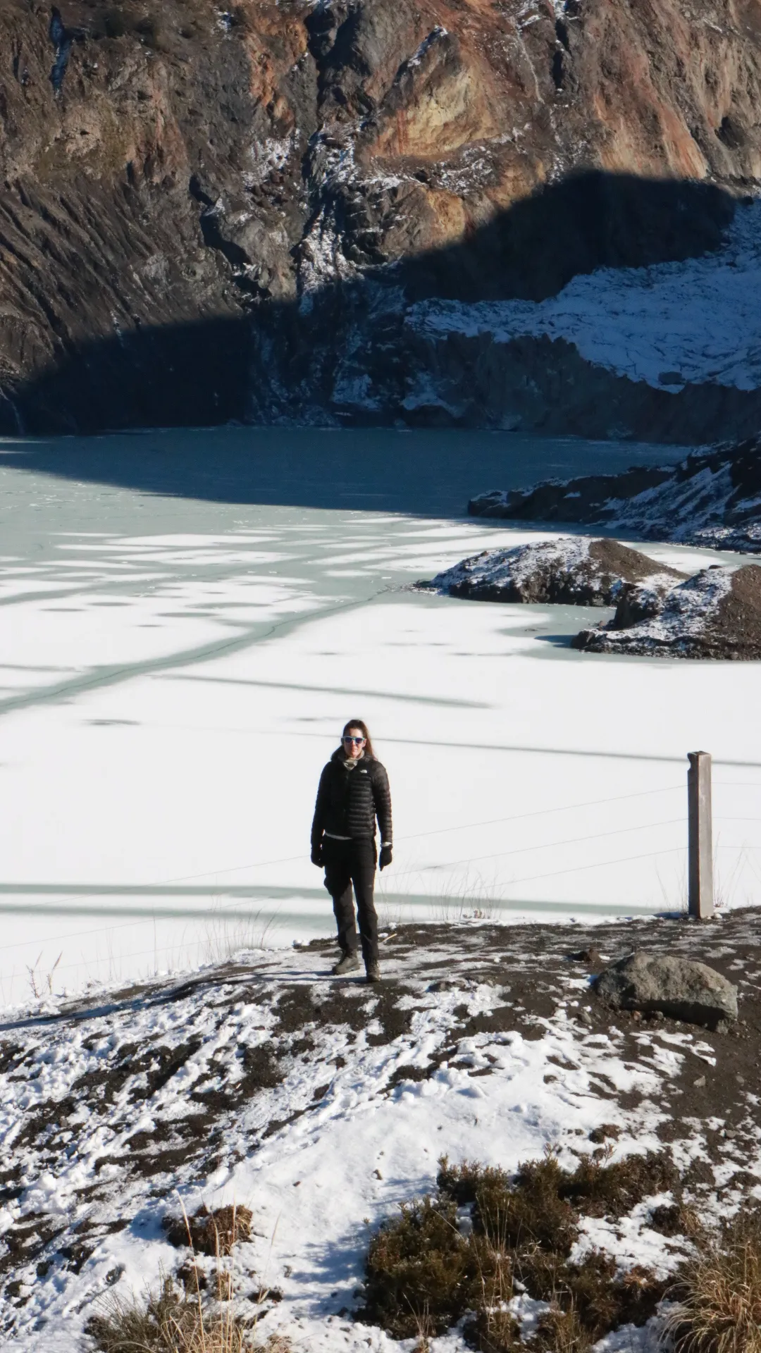 o que é trekking: Visitante diante de lago congelado cercado por rochas e neve em Bariloche, Patagônia argentina, no inverno