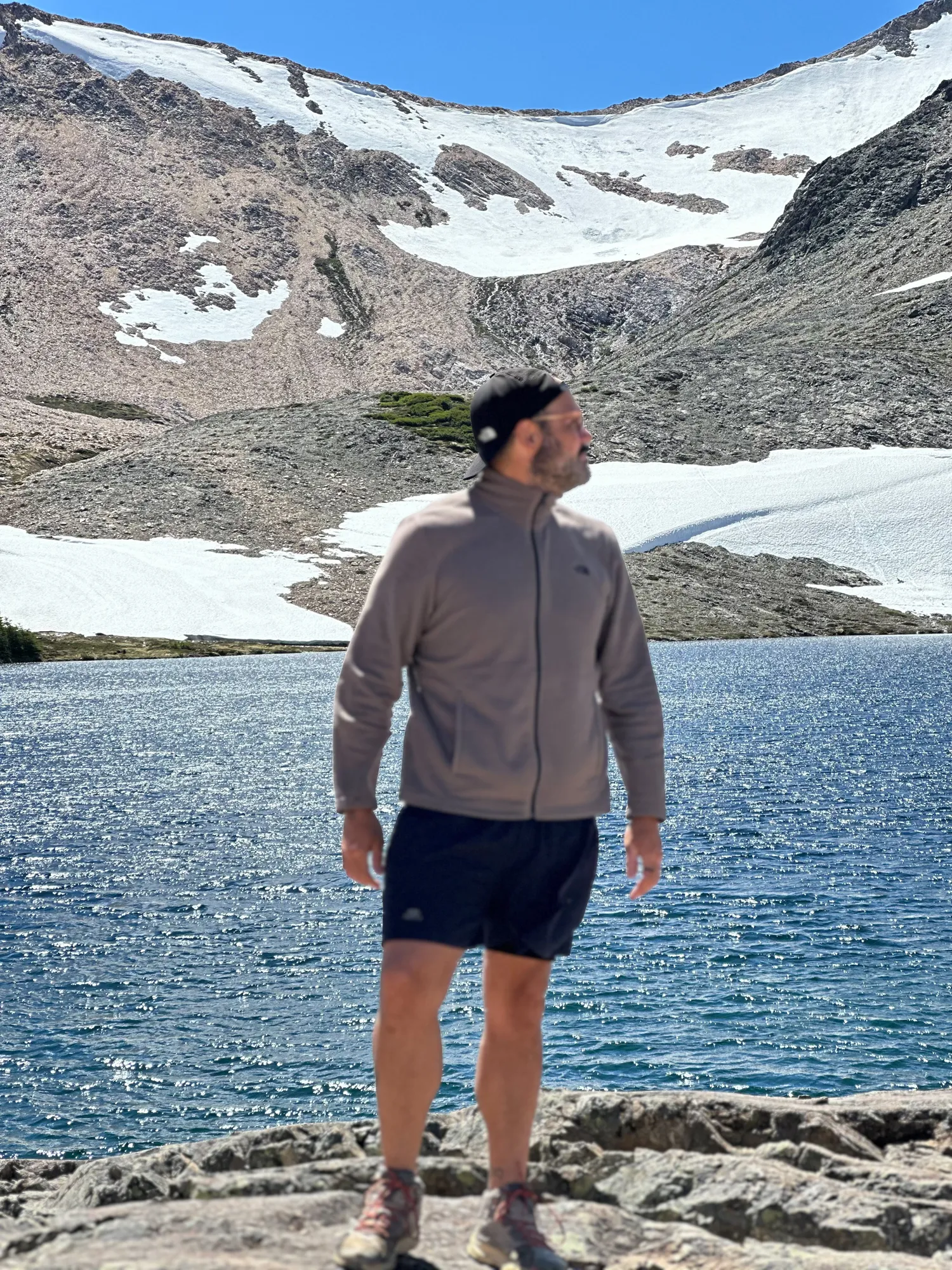 o que é trekking: Homem em trilha de trekking diante de lago glacial com montanhas nevadas na região de Bariloche, Patagônia argentina
