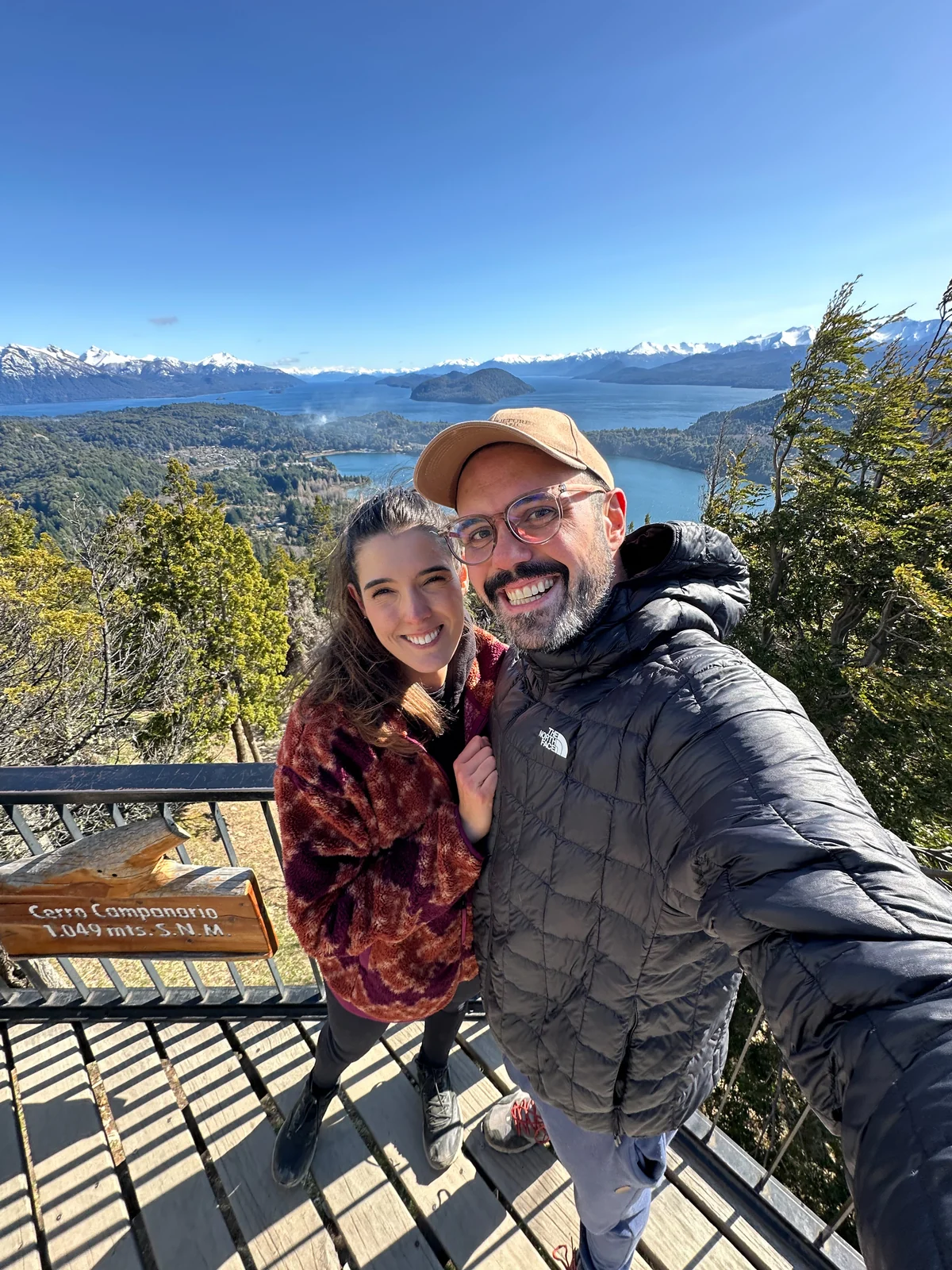 Gabriel e Dominique no mirante do Cerro Campanario, em Bariloche, com o Lago Nahuel Huapi e as montanhas ao fundo