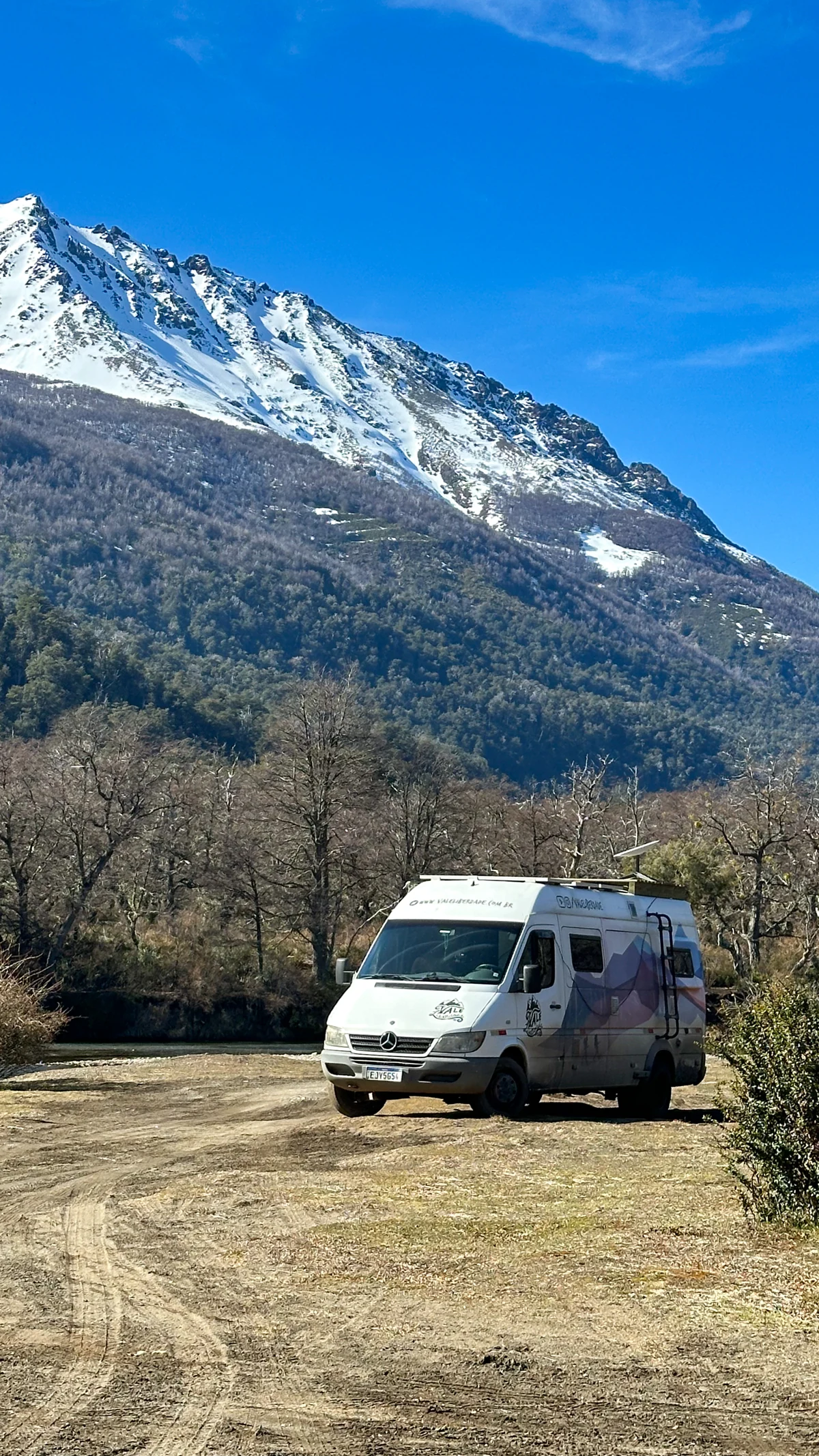 Motorhome branco estacionado com montanha nevada ao fundo, imagem coerente com a seção sobre onde estacionar
